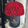 Round bouquet of red roses in a black hatbox