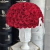 Red rose arrangement in a white sculpted face vase