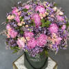 Pink peonies and lavender flowers in a dark green hat box