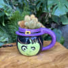 Small cactus arrangement in a purple witch-themed mug planter