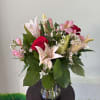 A graceful arrangement with soft pastel tones, rich accents, and fresh greenery