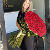 Large bouquet of red roses held by a smiling woman