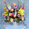 This garden-style spring arrangement is designed to feel bright, cheerful, and full