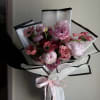 A garden-inspired bouquet featuring lush peonies, ranunculus, roses and anemones, arranged to