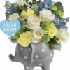 White and blue flowers in a gray polka-dot elephant container with a 