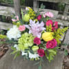 A sweet compact style arrangement filled with soft yellows, greens, and pinks