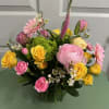 Mixed bouquet of pink and yellow flowers in a glass vase