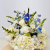 White and blue floral arrangement with roses and iris on a round table