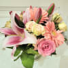 A mixture of pink flowers including tulips, gerbs, lilies, and spray roses