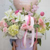 Soft blush and white lilies and roses take center stage in this