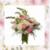 Creamy white roses and bright pink ranunculus mingle with soft pink tulips