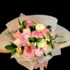 Pink and white bouquet of roses and peonies wrapped in white paper