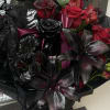 Bouquet of red and black roses with dark lilies in a glass vase