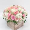 Pink and white roses arranged in a wooden box