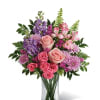A layered, garden-style bouquet of pink roses and lavender chrysanthemums makes a