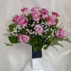 12 Deep purple roses complimented by baby's breath and foliage.