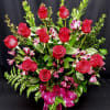 Red roses and pink alstroemeria in a tall bouquet with a magenta ribbon