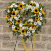 Heart-shaped floral wreath with sunflowers, white roses, and daisies on a stand