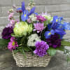 Vivid blue irises paired with soft purple carnations and cheerful pink daisies