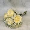 White roses gathered into a compact, rounded hand-tied bouquet create an immediate
