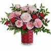 Pink and red flower arrangement in a red glass vase