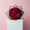 Bouquet of red roses wrapped in black paper with butterfly accents