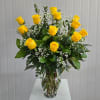 Yellow roses in a clear glass vase with white baby's breath