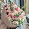 Bouquet of pink and white roses wrapped in blush paper