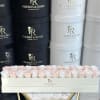 Box of pale pink and white roses in a branded hatbox