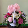 A charming basket arrangement featuring a mix of flowers and colors designed