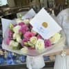 Bouquet of pink and white roses wrapped in white paper