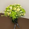 Green and white floral arrangement in a dark vase with ribbon