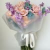 Bouquet of blush roses and purple flowers in a glass vase