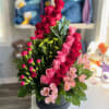 Compact black round box filled with red and pink roses, pink spray