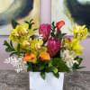 This dense, layered composition pairs orange calla lilies with small white accent
