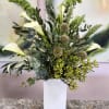 Tall white calla lilies rise like sculpted candles through a textured sea