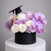 Graduation-themed flower box with roses and orchids in a black hatbox