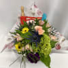 Mixed bouquet with pink, yellow, green, and purple flowers wrapped in floral paper