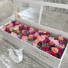A long white gift box with a clear hinged lid and white