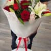 Deep red roses and large white lilies come together in a romantic