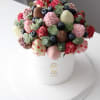 Chocolate-covered strawberries and blueberries in a white hatbox