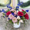 Vivid pink and soft blush roses set against cool, striking blue blooms
