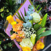 Bouquet of yellow and white roses with orange daisies and blue eucalyptus