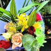 Bouquet of roses and yellow lilies wrapped in blue paper
