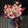 A lush cascade of pink roses and round blooms creates an immediate