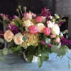 Mixed bouquet of pink and cream flowers in a white vase