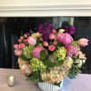 Pink and peach floral arrangement in a white vase