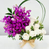 A dense cluster of vivid purple Dendrobium orchids paired with creamy white