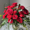 Vivid red roses and matching red carnations form a lush, rounded flower