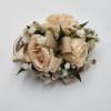 A wrist corsage featuring peach spray roses, peach ribbon and peach rhinestones.

Depending